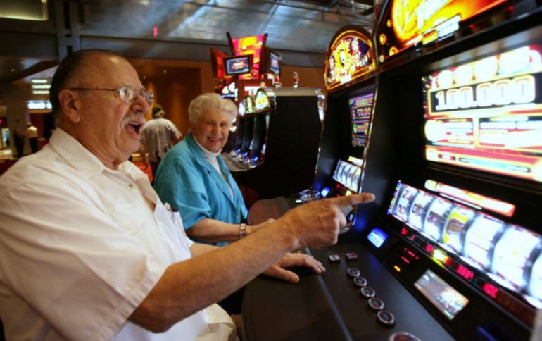 An Old Man Is Playing Slots